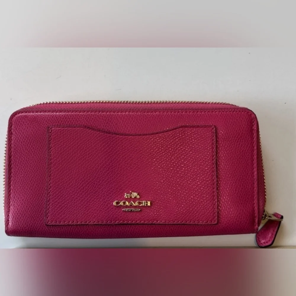 Coach Pink Leather Wallet with Gold Logo and Zip Closure.